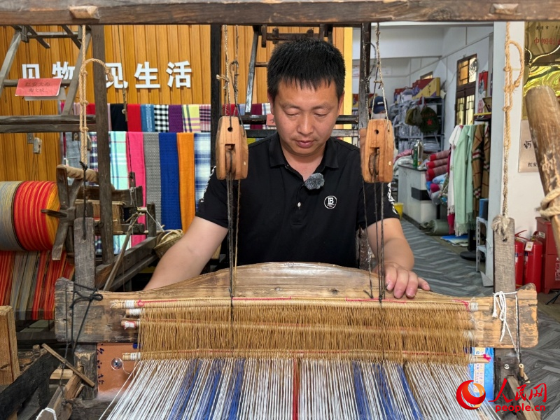 长胜街手作工坊里陶文成正在织布。人民网记者 周恬摄